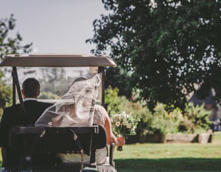 The bride and groom in golf buggy