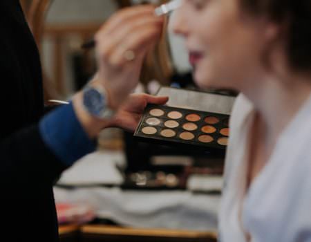 Bride having her makeup done at Bassmead Manor Barn