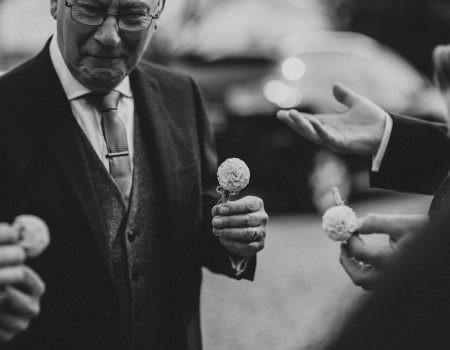 Men putting on their buttonholes