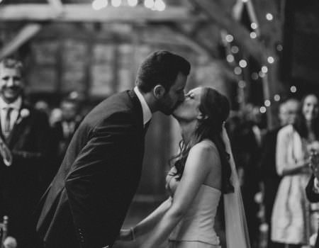 The bride and grooms first kiss at Bassmead Manor Barn