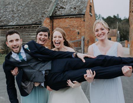 Bridesmaids holding up the groom
