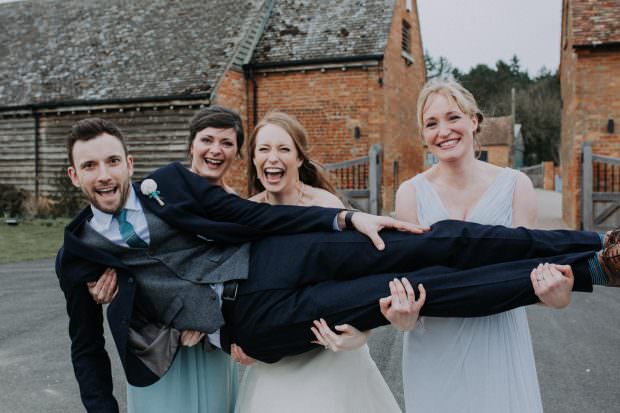 Bridesmaids holding up the groom