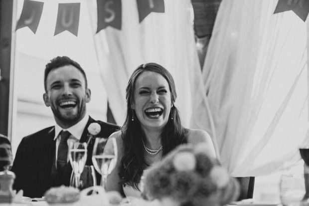 Bride and groom laughing during the speeches