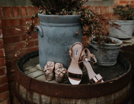 Brides shoes and flower girl shoes outside at Bassmead Manor Barns