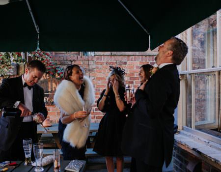 Guests laughing at the pub before wedding